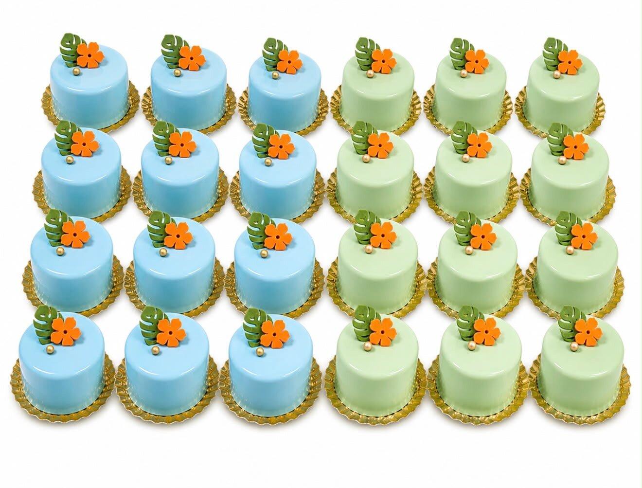 Mini prăjituri glazurate bleu și verde pastel, decorate cu floricele din zahăr